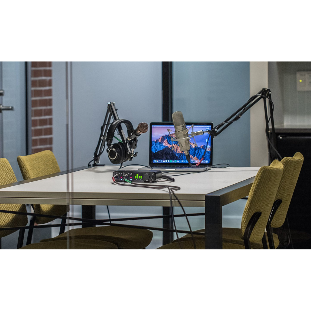 MOTU M4 Audio Interface in Podcast Studio Setup with Boom Microphone, Headphones and Laptop for Content Creation