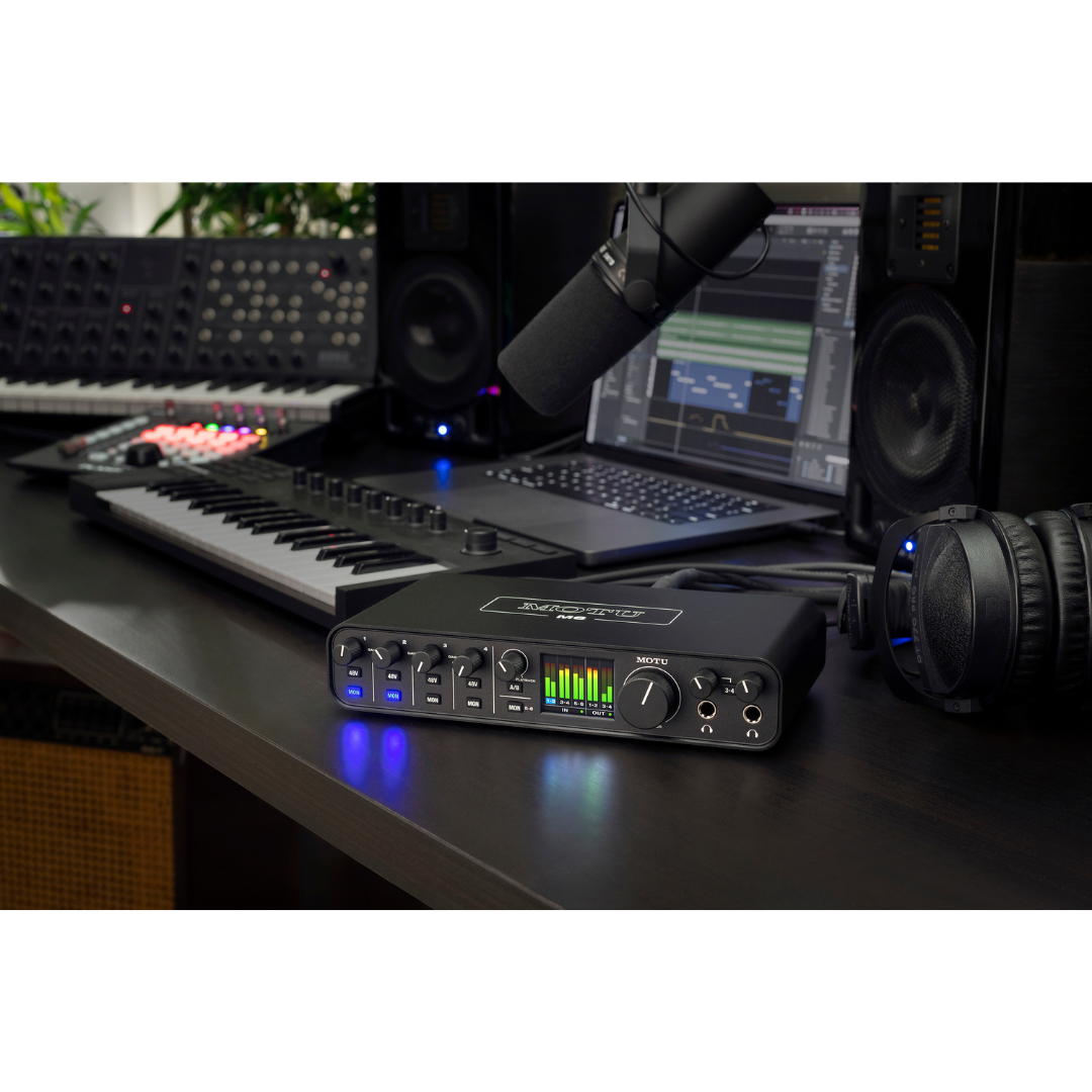 MOTU M6 Audio Interface on studio desk with MIDI keyboard, condenser mic, headphones and DAW laptop for music production