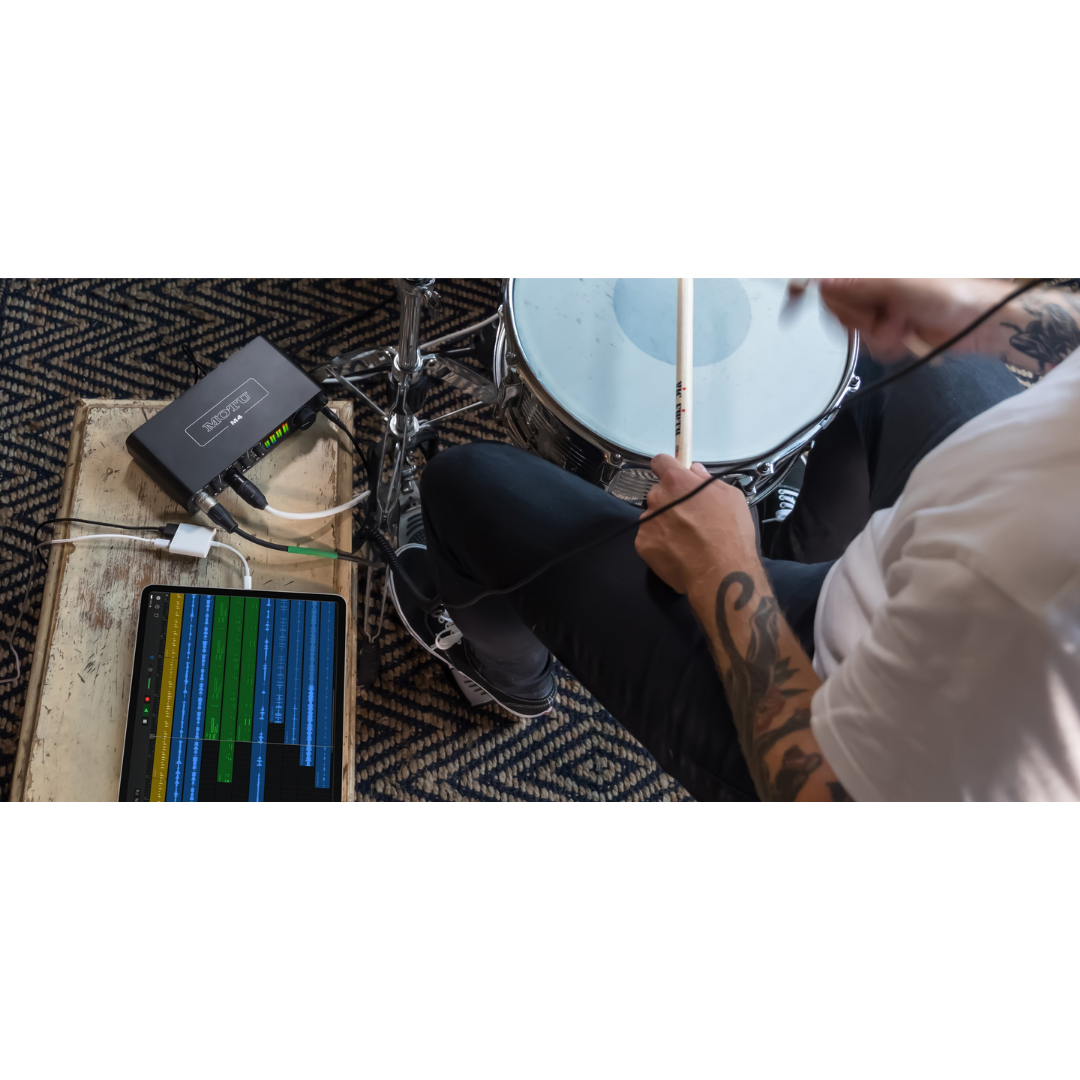 MOTU M4 USB-C Audio Interface in use by drummer with tablet meter display for live recording