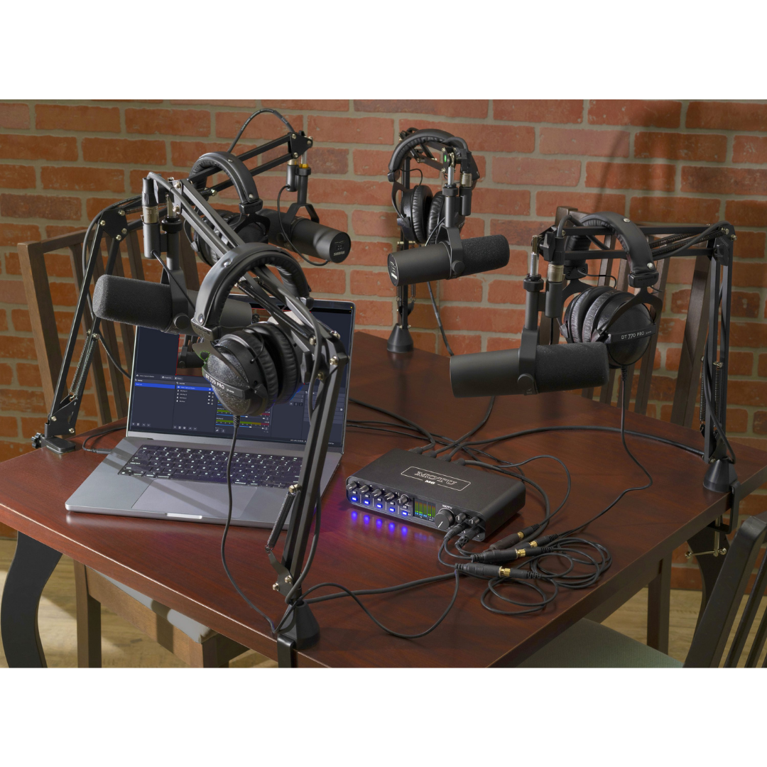 MOTU M6 Audio Interface in a podcast studio setup with multiple boom arm microphones, headphones and laptop